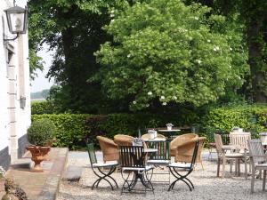 a patio with chairs and a table and a table and chairs at Het Kapelhuis in Thorn