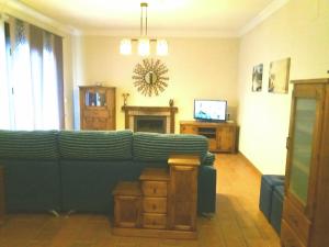 een woonkamer met een groene bank en een televisie bij Chalet Duna in El Palmar