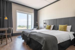 a bedroom with a large bed with a large window at Quality Hotel View in Malmö