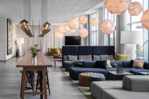 a lobby with blue couches and tables and lamps at Quality Hotel View in Malmö