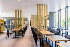 una sala da pranzo con tavoli, sedie e finestre di ibis Baden Neuenhof a Baden