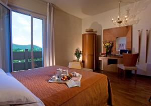 a hotel room with a bed with a tray of fruit on it at Hotel Terme Orvieto in Abano Terme
