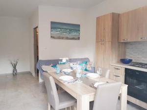 a kitchen with a table with plates and glasses on it at Apartmani Kulin 2 in Kaštela