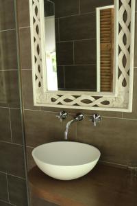 La salle de bains est pourvue d'un lavabo blanc et d'un miroir. dans l'établissement Het Kapelhuis, à Thorn