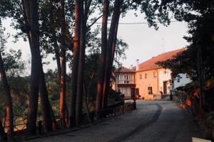 a house in the middle of a road with trees at Quinta da Mata - Turismo de Habitação in Chaves