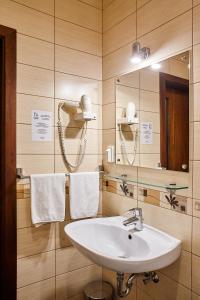 ein Badezimmer mit einem Waschbecken, einem Spiegel und Handtüchern in der Unterkunft Stariy Dvorik on Mopra in Kirow