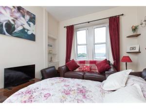 - un salon avec un lit, un canapé et une fenêtre dans l'établissement Homely Tenement for 2 near Botanic Gardens, à Édimbourg