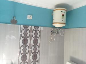 a bathroom with a shower with a blow dryer on the wall at CHÉRI HOME Stay in Khajurāho +47 photos