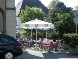 um grupo de mesas e cadeiras com guarda-sol em Hotel Gotthard em Brugg