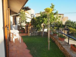 a small garden with a table and chairs on a patio at Casa Ulisse in Roccella Ionica