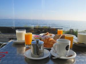 - Mesa con desayuno de café, pan y zumo de naranja en Refugio O Castro, en Barreiros