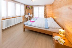 a bedroom with a large bed with a wooden wall at Haus Miranda Grächen in Grächen