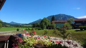 a view of a garden with mountains in the background at Hotel Garni Forsthaus Ruhpolding incl Chiemgau Karte in Ruhpolding +44 photos