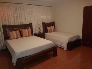 a bedroom with two beds and two nightstands at Casa Das Aguas Ferreas in Estação do Mogadouro