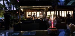 a candle on a table with a band playing in the background at Kuno - 2Br, Beachfront Jomtien in Jomtien Beach