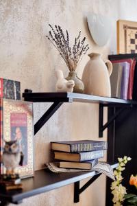 a shelf with books and a vase and a stack of books at Stariy Dvorik on Mopra in Kirov