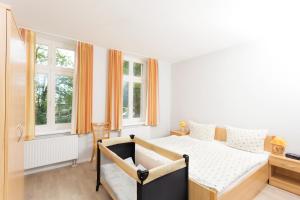 a bedroom with a bed and two windows at Apartmenthaus am Grienericksee in Rheinsberg