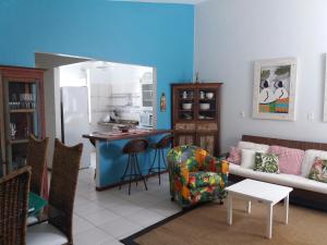 a living room with a couch and a kitchen at Vila Alegria in Bombinhas