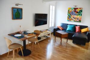 ein Wohnzimmer mit einem Sofa und einem Tisch in der Unterkunft Be our Guests in Nice Port Bonaparte in Nizza