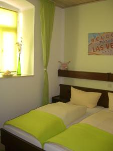 two beds in a bedroom with green curtains at Hotel-Restaurant Burg-Ramstein in Kordel