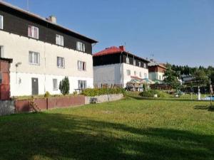 a large building with a grassy field in front of it at Hotel - penzion M&M in Jáchymov