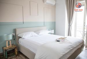 1 dormitorio con cama blanca y ventana en South Hands, en Nápoles