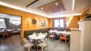 a restaurant with tables and chairs in a room at Rifugio La Montanara in Molveno
