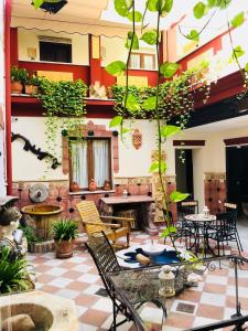 un patio avec des chaises, des tables et des plantes dans l'établissement Apartamentos Medina Qurtuba, à Cordoue