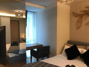 a bedroom with a bed and a chair and a mirror at Everyday Sukhumvit 11-13 Asok Nana Nightlife in Bangkok
