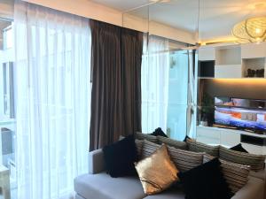 a living room with a couch and a large window at Everyday Sukhumvit 11-13 Asok Nana Nightlife in Bangkok