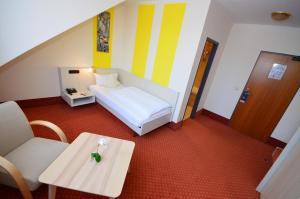 a small room with a bed and a table and a chair at CityHotel Uelzen in Uelzen
