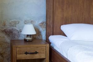 a lamp on a night stand next to a bed at Lauku māja "Zvejnieki" in Ķegums