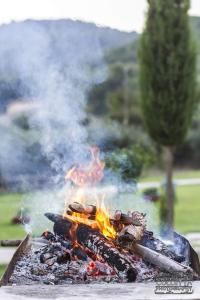 a large grill with flames and smoke on it at Casale Valle Agnese in Godrano