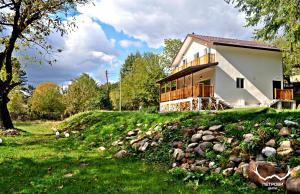 a house on a hill with a pile of rocks at Пе́трови Вили in Ribarica