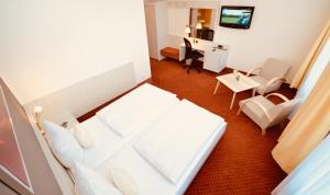 a hotel room with a bed and a desk at CityHotel Uelzen in Uelzen