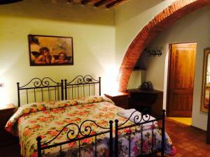 a bedroom with a bed with a floral bedspread at La Vecchia Camera in Montalcino