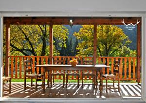 a wooden deck with a table and two chairs at Пе́трови Вили in Ribarica