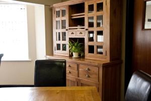 a wooden cabinet with a potted plant on top of it at Tricky's Hotel in Redruth +37 photos