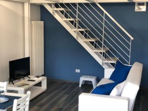 a living room with blue walls and a staircase at Splendido Loft al mare in Martinsicuro
