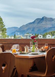 a table with food and wine glasses on it at Schweizerhaus Swiss Quality Hotel in Maloja