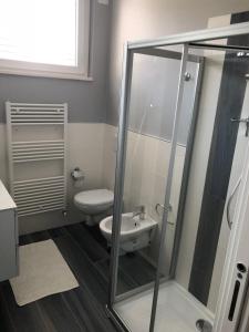 a bathroom with a toilet and a glass shower at Splendido Loft al mare in Martinsicuro +14 photos