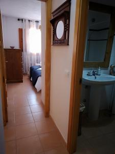 a bathroom with a sink and a bed and a mirror at VV Sweet Tabaiba "by henrypole home" in Los Cancajos