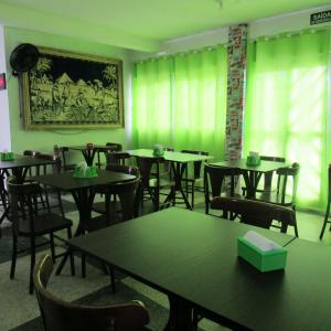 a dining room with green walls and tables and chairs at Pousada Girassol in Matinhos