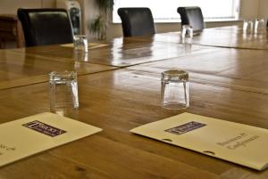 a wooden table with two glasses on top of it at Tricky's Hotel in Redruth