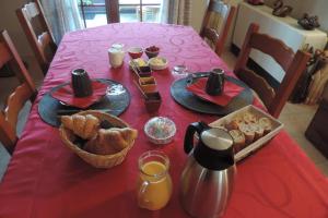 una mesa con un mantel rojo con comida. en Le jardin des paons en Issac