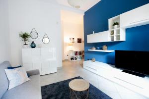 a living room with a blue accent wall at Quater Apartments - Milano in Milan