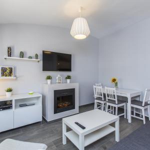 a living room with a fireplace and a table and chairs at Casa Alma in Marbella