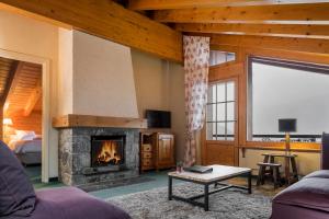 a living room with a fireplace and a bed at Hotel Montpelier in Verbier