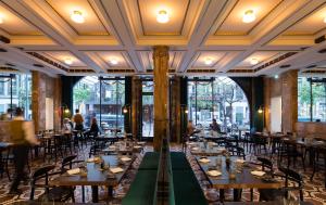 a restaurant with tables and chairs in a room with windows at Pestana Porto - A Brasileira, City Center & Heritage Building in Porto