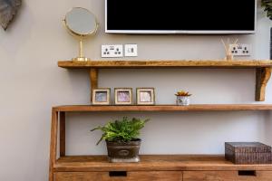 a television on a shelf with a potted plant at The George Inn in Maulden